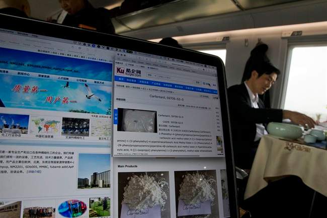 In this Oct. 26, 2016, photo, a man drinks tea near a computer screen displaying websites of companies selling carfentanil online on a train leaving Beijing on Wednesday, Oct. 26, 2016. Use of the deadly chemical carfentanil by drug dealers has exploded across the U.S., with more than 400 seizures in eight states since July, fueled by a thriving trade from China, the AP has found.
