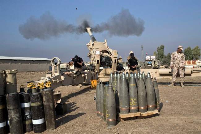 Iraqi army soldiers fire an artillery round at Islamic State positions in Bartilla, about 9 miles (15 km) east of Mosul, Iraq, Monday, Nov. 7, 2016. 