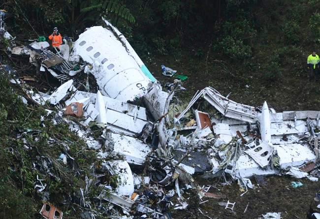 Rescue workers stand at the wreckage site of a chartered airplane that crashed outside Medellin, Colombia, Tuesday, Nov. 29, 2016. The plane was carrying the Brazilian first division soccer club Chapecoense team that was on it's way for a Copa Sudamericana final match against Colombia's Atletico Nacional.