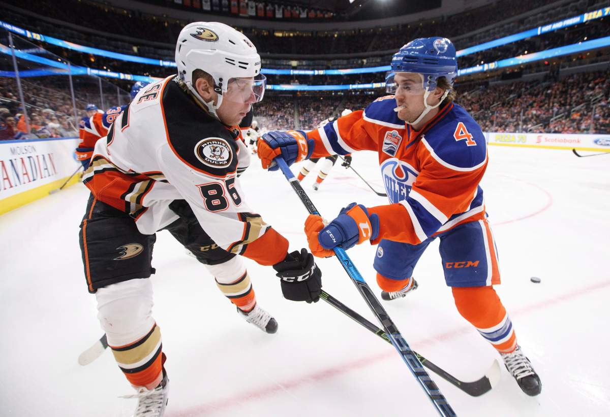 Anaheim Ducks' Ondrej Kase (86) is checked by Edmonton Oilers' Kris Russell (4) during third period NHL action in Edmonton, Alta., on Saturday, December 3, 2016. 