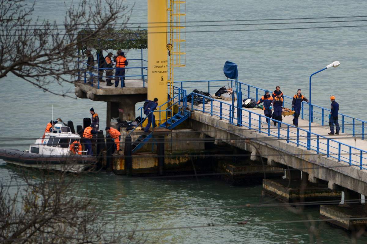 Russian rescue workers carry a body from the wreckage of the crashed plane, at a pier just outside Sochi, Russia, Sunday, Dec. 25, 2016. Russian ships, helicopters and drones are searching for bodies after a plane carrying 93 people crashed into the Black Sea. The plane was taking the Alexandrov Ensemble, a military choir, to perform at Russia’s air base in Syria when it went down shortly after takeoff.