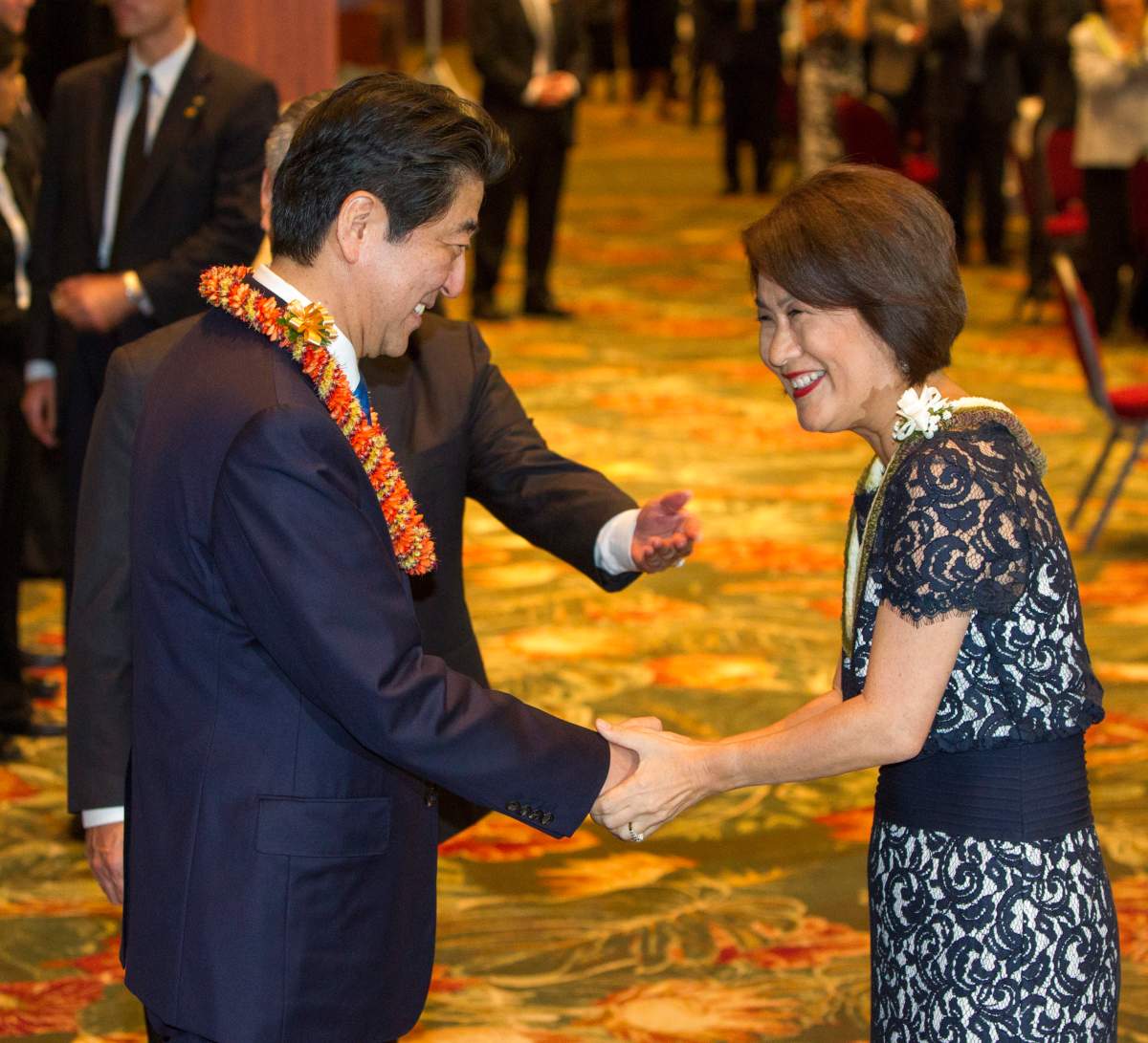 Japanese Prime Minister Shinzo Abe, left, shakes hands with Hawaii governor’s wife Dawn Ige after receiving a Hawaii flower lei at a dinner held in Abe’s honor, Monday, Dec. 26, 2016, in Honolulu. Abe laid wreaths at various cemeteries and memorials Monday ahead of a visit to the site of the 1941 bombing that plunged the United States into World War II. The USS Arizona Memorial at Pearl Harbor will be closed to the public Tuesday when Abe visits the historic site, joined by U.S. President Barack Obama, who is vacationing in Hawaii with his family.