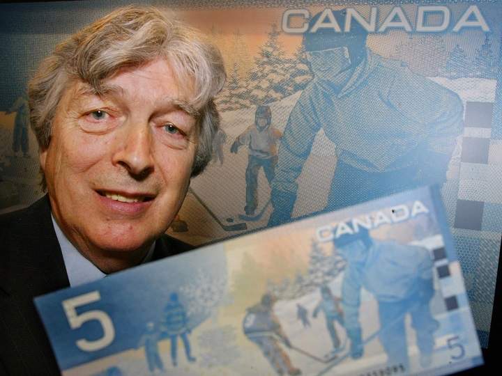 Author Roch Carrier poses with a new Canadian five dollar bill during an unveiling ceremony in Montreal, Wednesday, March 27, 2002. Excerpts from Carrier’s book, The Hockey Sweater, appears on a background of various scenes of children at play. (CP PHOTO/Paul Chiasson)