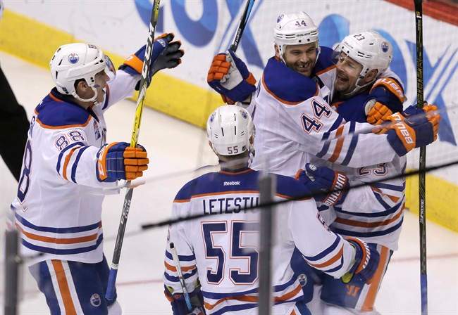 Edmonton Oilers left wing Matt Hendricks (23) celebrates with Zack Kassian (44), Brandon Davidson (88), and Mark Letestu (55) after scoring a goal against the Arizona Coyotes in the second period during an NHL hockey game, Wednesday, Dec. 21, 2016, in Glendale, Ariz. 