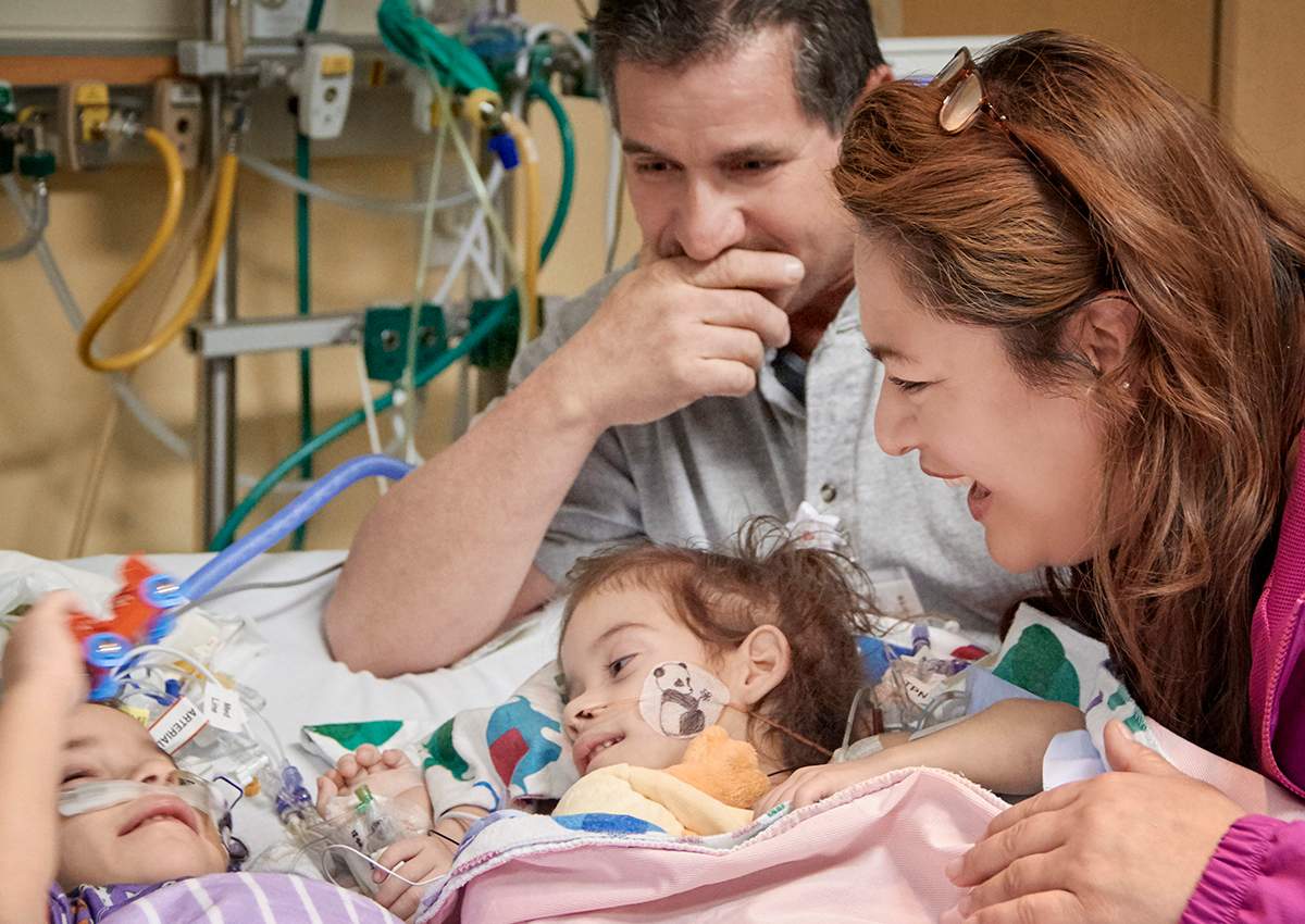 In this Monday, Dec. 12, 2016, photo provided by the Lucile Packard Children's Hospital Stanford, the formerly conjoined twin girls, Eva, left, and Erika, right, reunite for the first time since separation surgery with their parents, Arturo Sandoval and his wife, Aida, in Palo Alto, Calif.