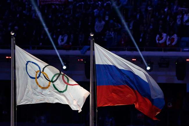 The Russian national flag, right, flies next to the Olympic flag during the closing ceremony of the 2014.THE CANADIAN PRESS/AP, Matthias Schrader.