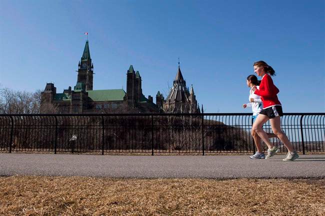 Joggers make their way through Majors Hill Park in downtown Ottawa in view of Parliament Hill on Wednesday, March 17, 2010.