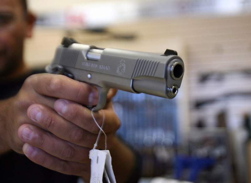 A man handles a handgun for sale in this file image. 