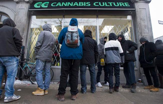 People wait outside Cannabis Culture in Montreal, Friday, December 16, 2016. If police catch you with pot before July 2018, you can still face charges.