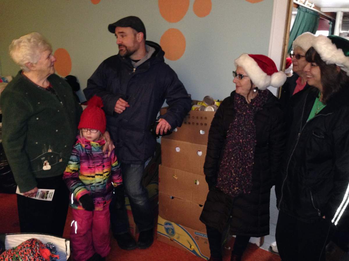 Volunteers with the Take Action Society talk with Frances Hunter, Food Bank Manager for the North Dartmouth Outreach Centre after dropping off some donations.