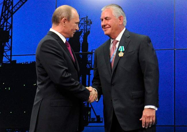In this photo taken Thursday, June 21, 2012, Russian President Vladimir Putin presents ExxonMobil CEO Rex Tillerson with a Russian medal at an award ceremony of heads and employees of energy companies at the St. Petersburg economic forum in St. Petersburg, Russia. Tillerson, now U.S. secretary of state, will travel to Moscow next week.
