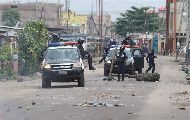 Riot police remove barricade used to block a road during a protest in Kinshasa, Democratic Republic of Congo, Tuesday, Dec. 20, 2016.