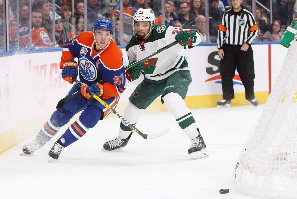 Minnesota Wild's Matt Dumba (24) defends against Edmonton Oilers' Connor McDavid (97) during second period NHL action in Edmonton, Alta., on Sunday December 4, 2016. THE CANADIAN PRESS/Jason Franson.