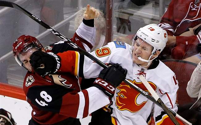 Calgary Flames left wing Matthew Tkachuk (19) mixes it up with Arizona Coyotes left wing Jordan Martinook (48) during the second period of an NHL hockey game Thursday, Dec. 8, 2016, in Glendale, Ariz.