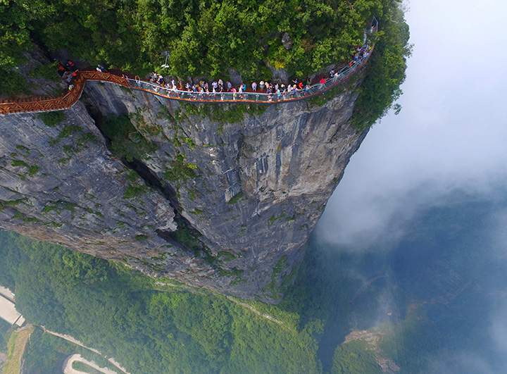 People walk on a sightseeing platform in Zhangjiajie, in China’s Hunan Province on Aug. 1, 2016.