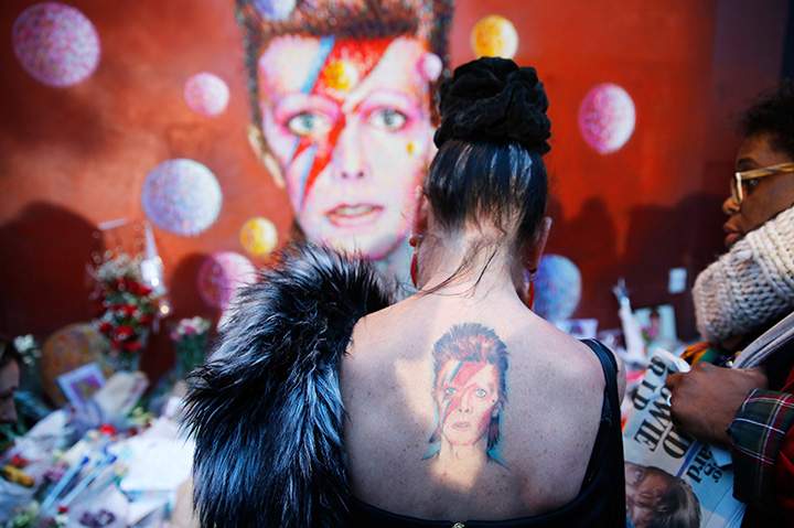 A woman with a Ziggy Stardust tattoo visits a mural following the death of David Bowie in Brixton, south London on Jan. 11, 2016.