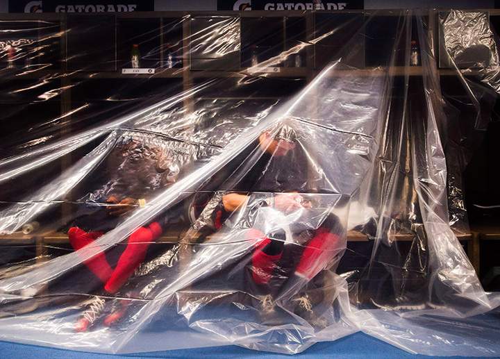 Ottawa Redblacks’ Travon Van, left, and Trevor Harris hide under a plastic covering after defeating the Calgary Stampeders in overtime of Grey Cup football action on Sunday, Nov. 27, 2016 in Toronto.