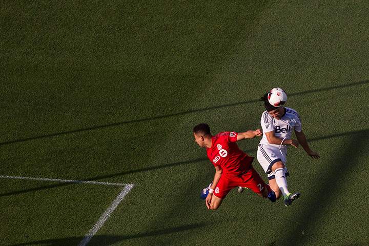 Vancouver Whitecaps’ Christian Bolanos tries to direct a header despite pressure from Toronto FC’s Justin Morrow during first half Canadian Cup action in Toronto on June 21, 2016.