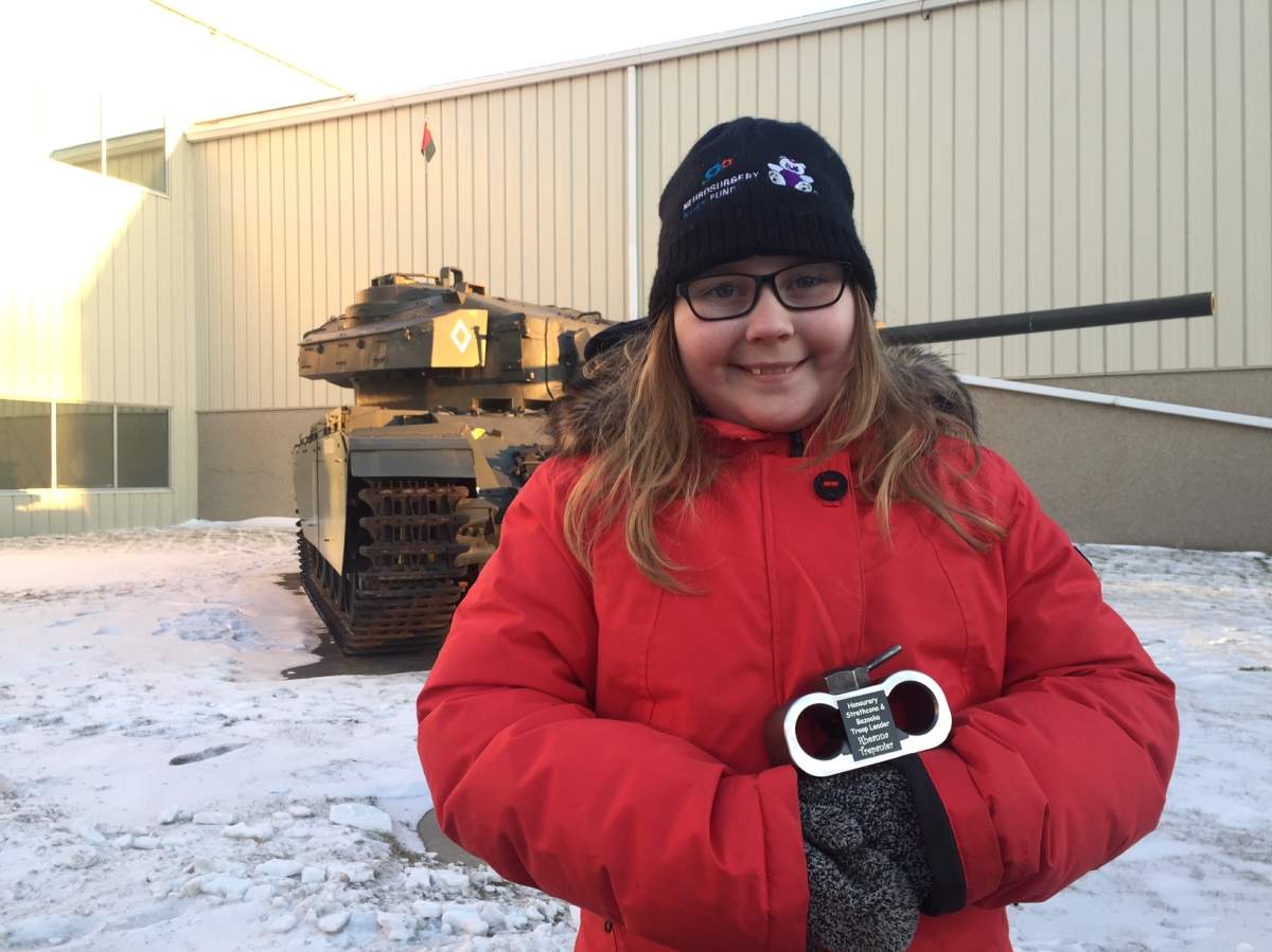 Rheanna Trepanier, 10, holding her handmade tank after riding in a tank at the Edmonton Garrison.