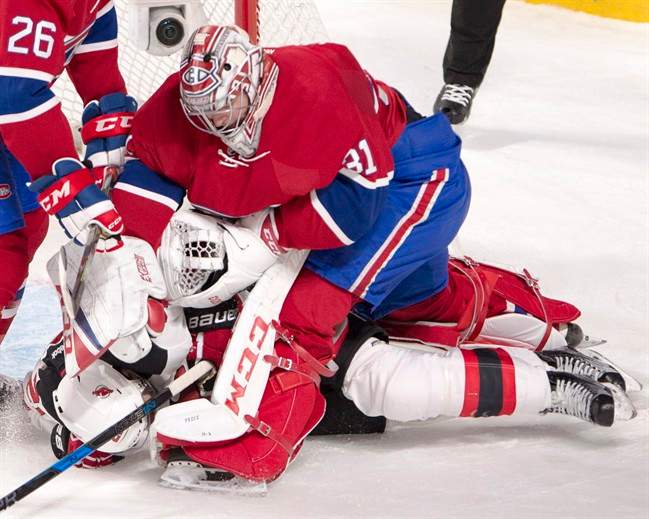 Montreal Canadiens goalie Carey Price (31) punches New Jersey Devils right wing Kyle Palmieri (21) after Palmieri ran into him during first period NHL hockey action Thursday, December 8, 2016 in Montreal.