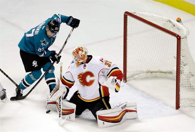 Calgary Flames' Chad Johnson, right, deflects a shot next to San Jose Sharks' Joonas Donskoi during the first period of an NHL hockey game Tuesday, Dec. 20, 2016, in San Jose, Calif. 