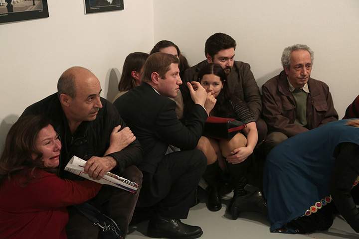 People react after the Russian Ambassador to Turkey, Andrei Karlov, was shot at a photo gallery in Ankara, Turkey, Monday, Dec. 19, 2016.