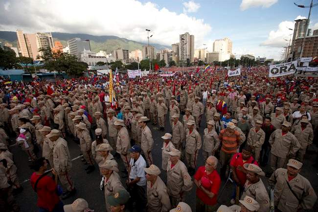 Members of the Venezuelan Militia sing the national anthem during a pro-government rally in Caracas, Venezuela, Saturday, Dec. 17, 2016.