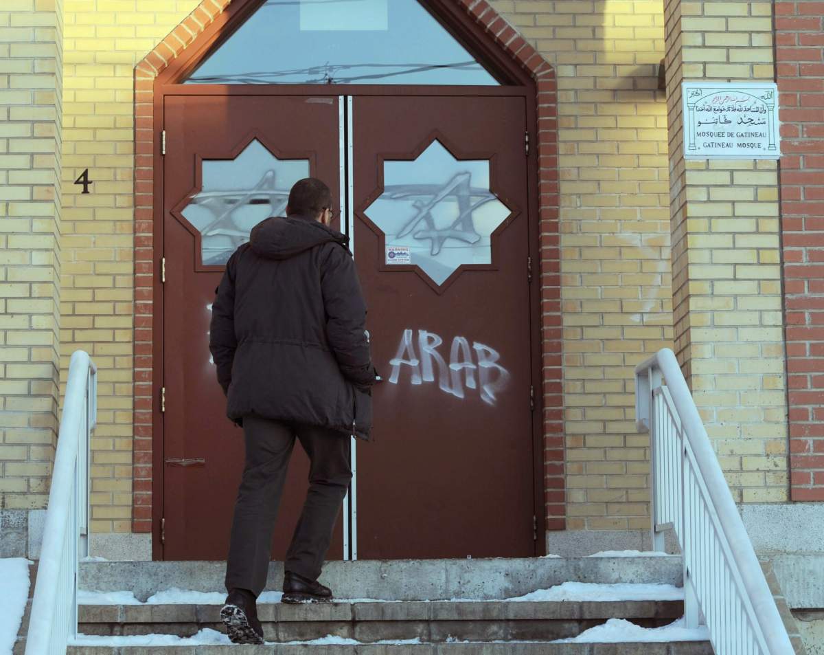 A man looks at new vandalism on the front door of the Outaouais Islamic Centre in Gatineau , Quebec on Thursday, January 5, 2012. The Gatineau mosque was also vandalized earlier this week when windows were smashed and a car was attempted to be lit on fire.