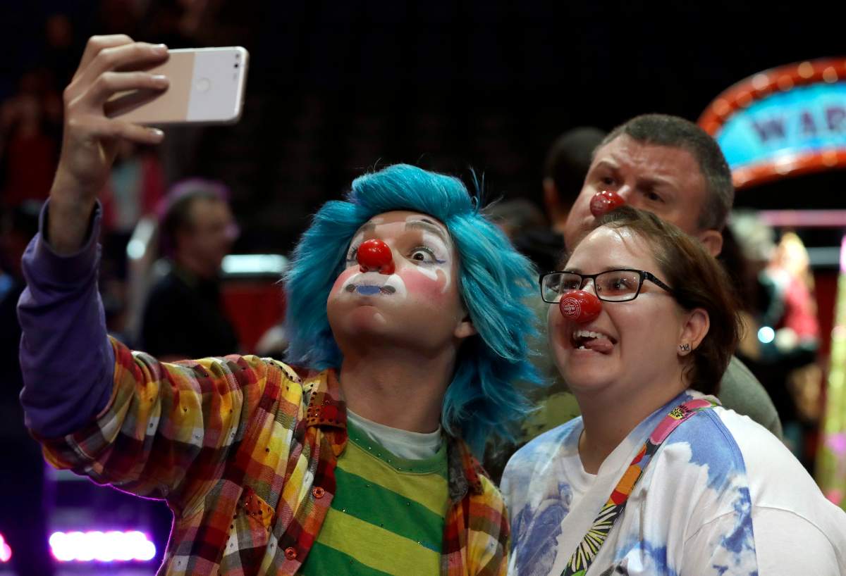 A Ringling Bros. and Barnum & Bailey clown takes a selfie with Jennifer and Kevin Fox, of Fort Pierce, Fla., during a pre show for fans Saturday, Jan. 14, 2017, in Orlando, Fla. The Ringling Bros. and Barnum & Bailey Circus will end the “The Greatest Show on Earth” in May, following a 146-year run of performances. Kenneth Feld, the chairman and CEO of Feld Entertainment, which owns the circus, told The Associated Press, declining attendance combined with high operating costs are among the reasons for closing.