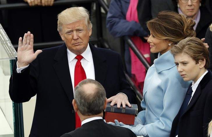 US President Donald Trump takes the oath of office with his wife Melania and son Barron at his side, during his inauguration at the U.S. Capitol in Washington, U.S., January 20, 2017.