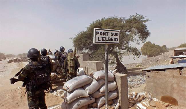FILE - In this Wednesday, Feb. 25, 2015, file photo, Cameroon soldiers stand guard at a lookout post as they take part in operations against the Islamic extremists group Boko Haram, their guard post is on Elbeid bridge, left rear, that separates northern Cameroon form Nigeria's Borno state near the village of Fotokol, Cameroon. (AP Photo/Edwin Kindzeka Moki, File).