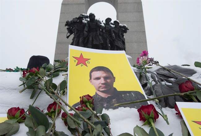 Flowers and photos lie on the Tomb of the Unknown Soldier following a memorial to Nazzareno Tassone, who was killed on Dec. 21 while fighting alongside the Kurdish People's Defense Units, Monday January 9, 2017 in Ottawa. 