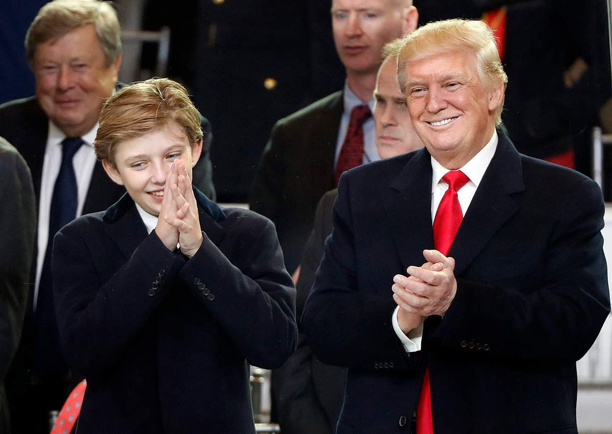 President Donald Trump, right, smiles with his son Barron as they view the 58th Presidential Inauguration parade for President Donald Trump in Washington. Friday, Jan. 20, 2017.