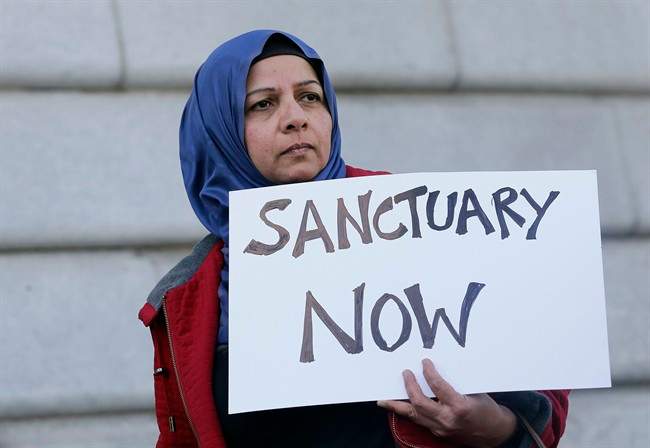 Moina Shaiq holds a sign at a rally outside of City Hall in San Francisco, Wednesday, Jan. 25, 2017. President Donald Trump moved aggressively to tighten the nation's immigration controls Wednesday, signing executive actions to jumpstart construction of his promised U.S.-Mexico border wall and cut federal grants for immigrant-protecting "sanctuary cities."