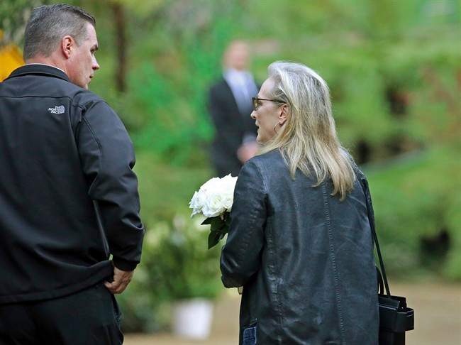 Actress Meryl Streep arrives with flowers at a memorial service at the homes of Debbie Reynolds and her daughter Carrie Fisher in Los Angeles Thursday, Jan. 5, 2017. Reynolds died Dec. 28 at the age of 84, a day after her daughter died at the age of 60. Streep starred in the film, "Postcards From the Edge," based on Fisher's 1987 semi-autobiographical novel of the same title.