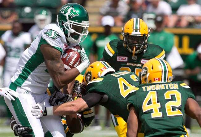 Saskatchewan Roughriders Shamawd Chambers (17) is surrounded by Edmonton Eskimos during first half CFL pre-season action in Edmonton, Alta., on Saturday June 18, 2016. Receiver Shamawd Chambers, who was the top Canadian in the 2015 Grey Cup game, was among four veteran players released Friday by the Saskatchewan Roughriders.