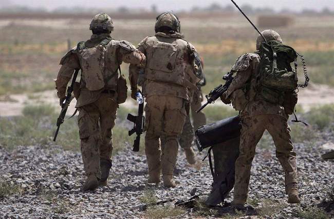 Canadian soldiers help a comrade, center, get on a helicopter after he was injured in an IED blast during a patrol outside Salavat, in the Panjwayi district, southwest of Kandahar, Afghanistan, Monday, June 7, 2010. 