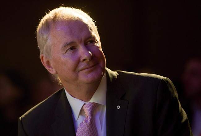 John Furlong, Own The Podium board chairman and former CEO of the Vancouver Olympics, watches a video of 2010 Olympic moments before addressing a Vancouver Board of Trade luncheon in Vancouver, B.C., on Wednesday November 25, 2015. Furlong will be back at the podium for a University of British Columbia fundraising event after the abrupt cancellation of his speech and subsequent apology from the university.