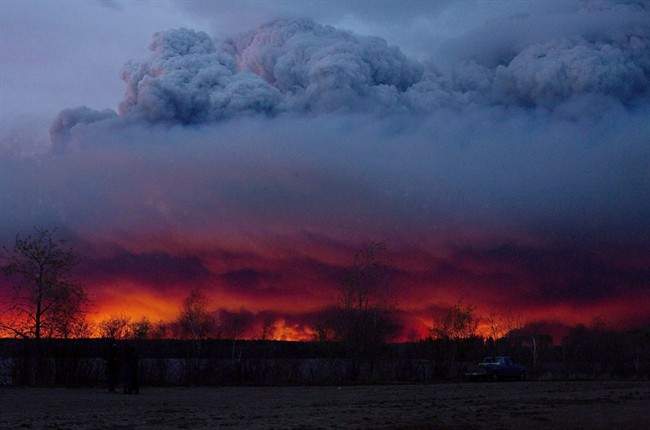 A wildfire moves towards the town of Anzac from Fort McMurray, Alta., on Wednesday May 4, 2016. An assessment of the total financial impact of last spring's Fort McMurray wildfire is pegging the direct and indirect costs of the blaze at almost $10 billion.THE CANADIAN PRESS/Jason Franson.