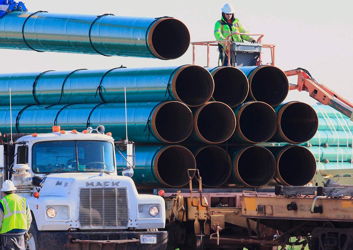 In this May 9, 2015, file photo, workers unload pipes for the proposed Dakota Access oil pipeline that would stretch from the Bakken oil fields in North Dakota to Illinois. 
