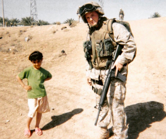 U.S. marine Dario DiBattista and an Iraqi girl pose for a photo in Anbar province, Iraq in February 2004.