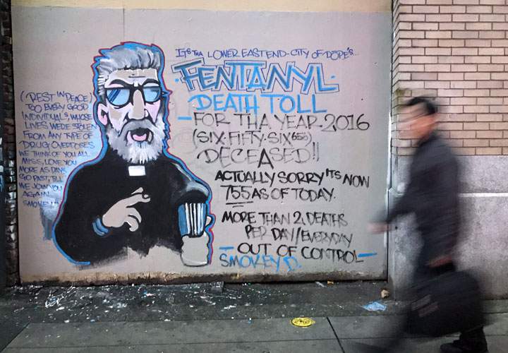 A man walks past a mural about the fentanyl and opioid overdose crisis