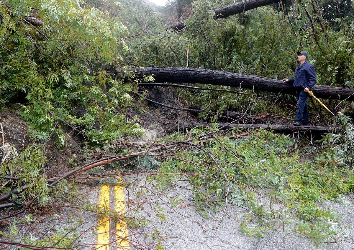 Miguel Deniz looks up at a hillside above a slide that blocked Highway 1, just south of Fernwood in Big Sur on Monday, Jan. 9, 2017, after a storm passed through Monterey County. (David Royal/The Monterey County Herald via AP)