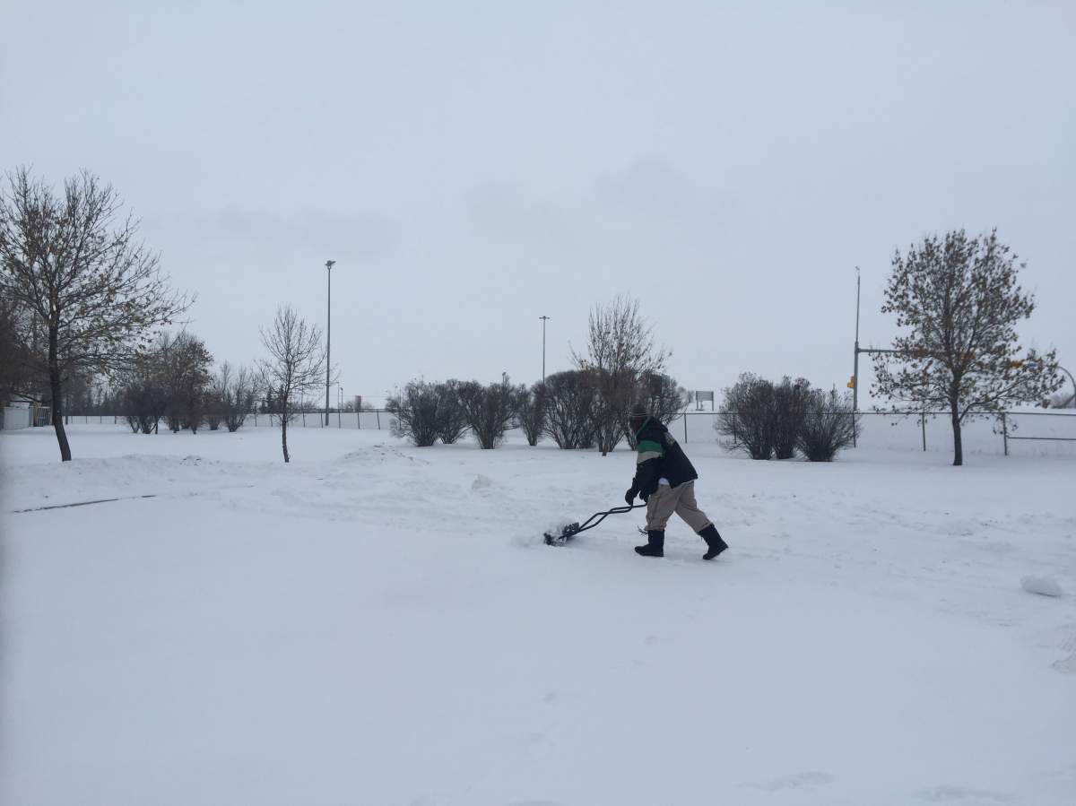 A Regina resident clears snow off his property.