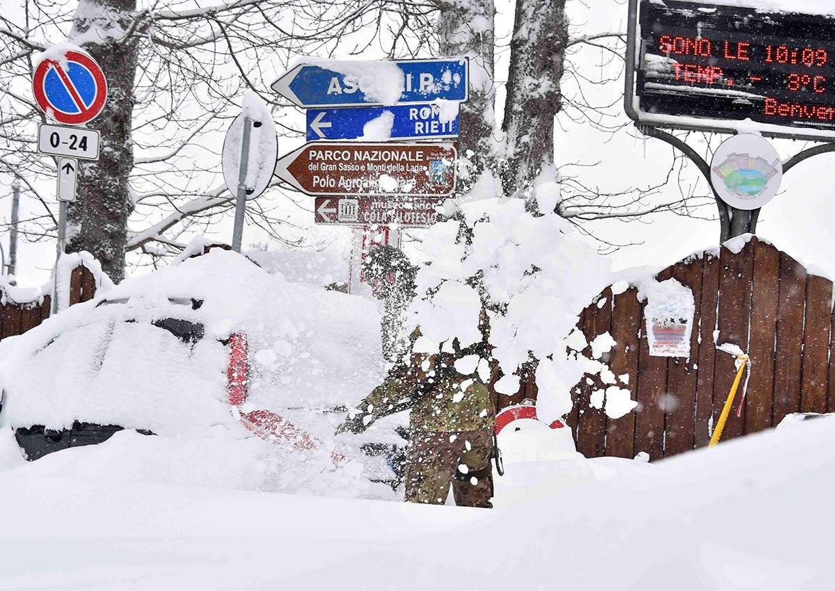 A soldier shovels snow in Amatrice, central Italy, Wednesday, Jan. 18, 2017. 