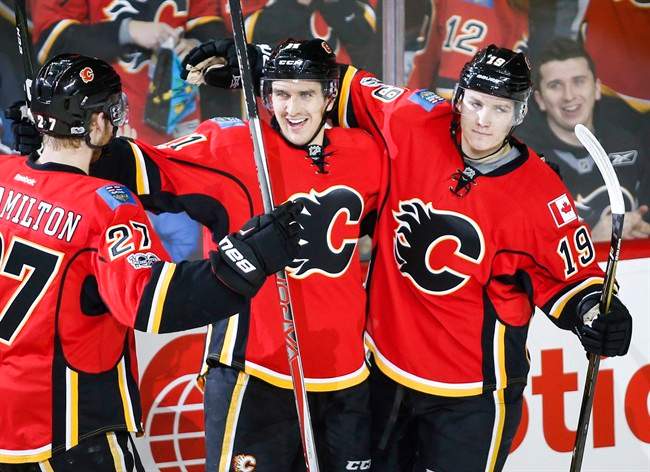 Calgary Flames' Mikael Backlund, centre, from Sweden, celebrates his goal with Dougie Hamilton, left, and Matthew Tkachuk during second period NHL hockey action against the Colorado Avalanche in Calgary, Wednesday, Jan. 4, 2017.