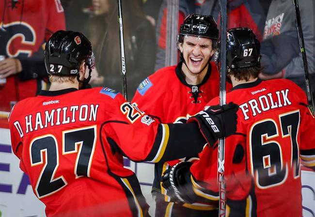 Calgary Flames' Mikael Backlund, centre, from Sweden, celebrates his first goal with teammates during second period NHL hockey action in Calgary, Tuesday, Jan. 17, 2017.