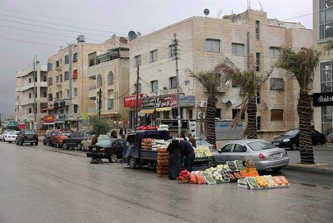 A vendor sells produce from a truck in the Thraa al-Gharbi neighbourhood in Amman, Jordan on Sat. Jan. 28, 2017. (AP Photo/Sam McNeil)