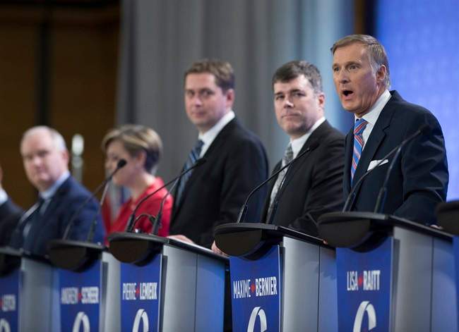 Leadership candidate Maxime Bernier, right, speaks during the Conservative Party French language leadership debate, Tuesday, January 17, 2017 in Quebec City. Looking on are Erin O'Toole, from the left, Kellie Leitch, Andrew Scheer, and Pierre Lemieux. 