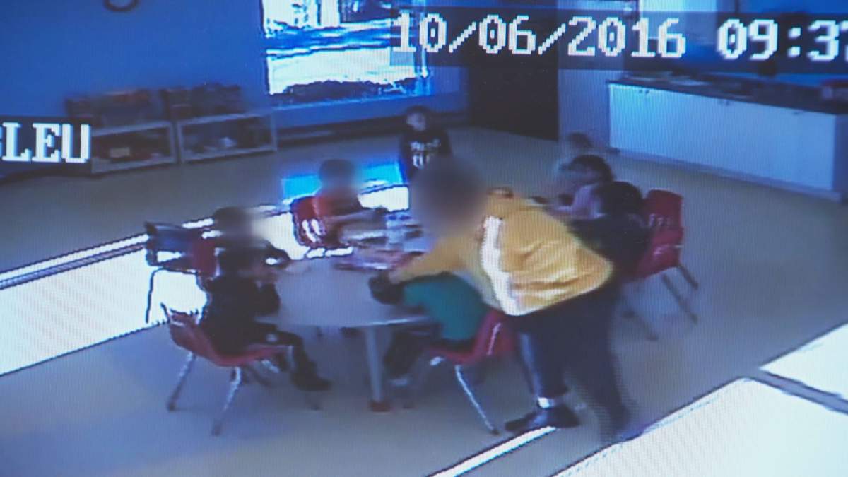 A daycare worker at Les Canaries 2 is seen on a surveillance video forcefully pushing a child's head against a table.